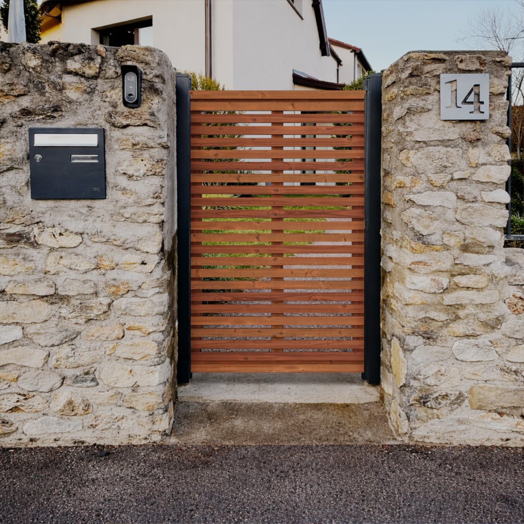 Portillon en bois Douglas à lames horizontales installé entre deux piliers en pierre à l’entrée d’une maison, avec boîte aux lettres et numéro de rue intégrés.