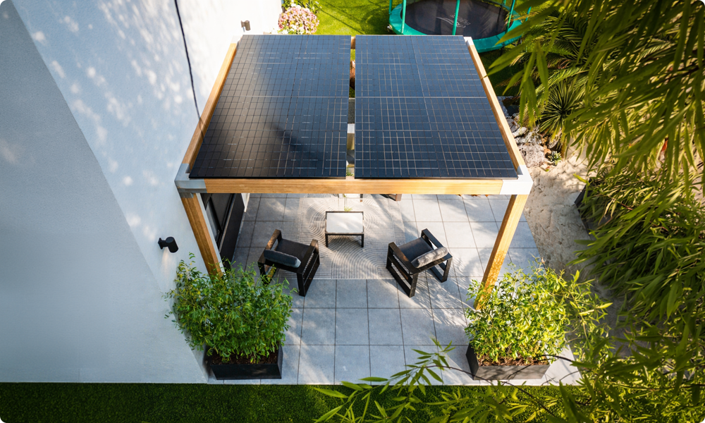 Pergola bois : le guide complet pour choisir, poser et entretenir votre structure en 2026 5 Pergola bois adossée à la maison avec panneaux solaires intégrés sur le toit