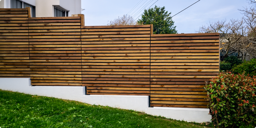 Clôture bois : guide complet 2026 (types, pose, prix, entretien) 5 Schéma installation clôture bois en escalier sur terrain en pente