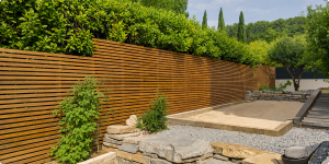 Aménagements de jardin en bois à monter soi-même 15 Clôture bois claire-voie moderne en lames horizontales dans un jardin paysager avec massif minéral et haie dense