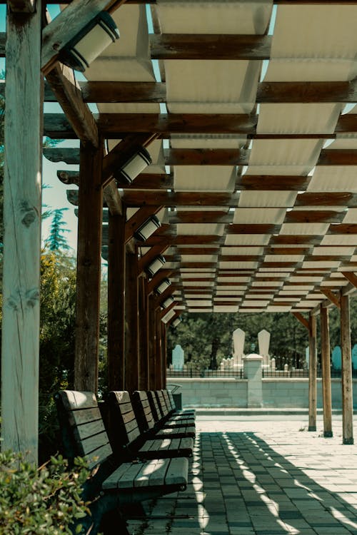 Prix pergola bois : quel budget prévoir ? 1 Pergola pin lamellé-collé dans un jardin français avec jeux ombre