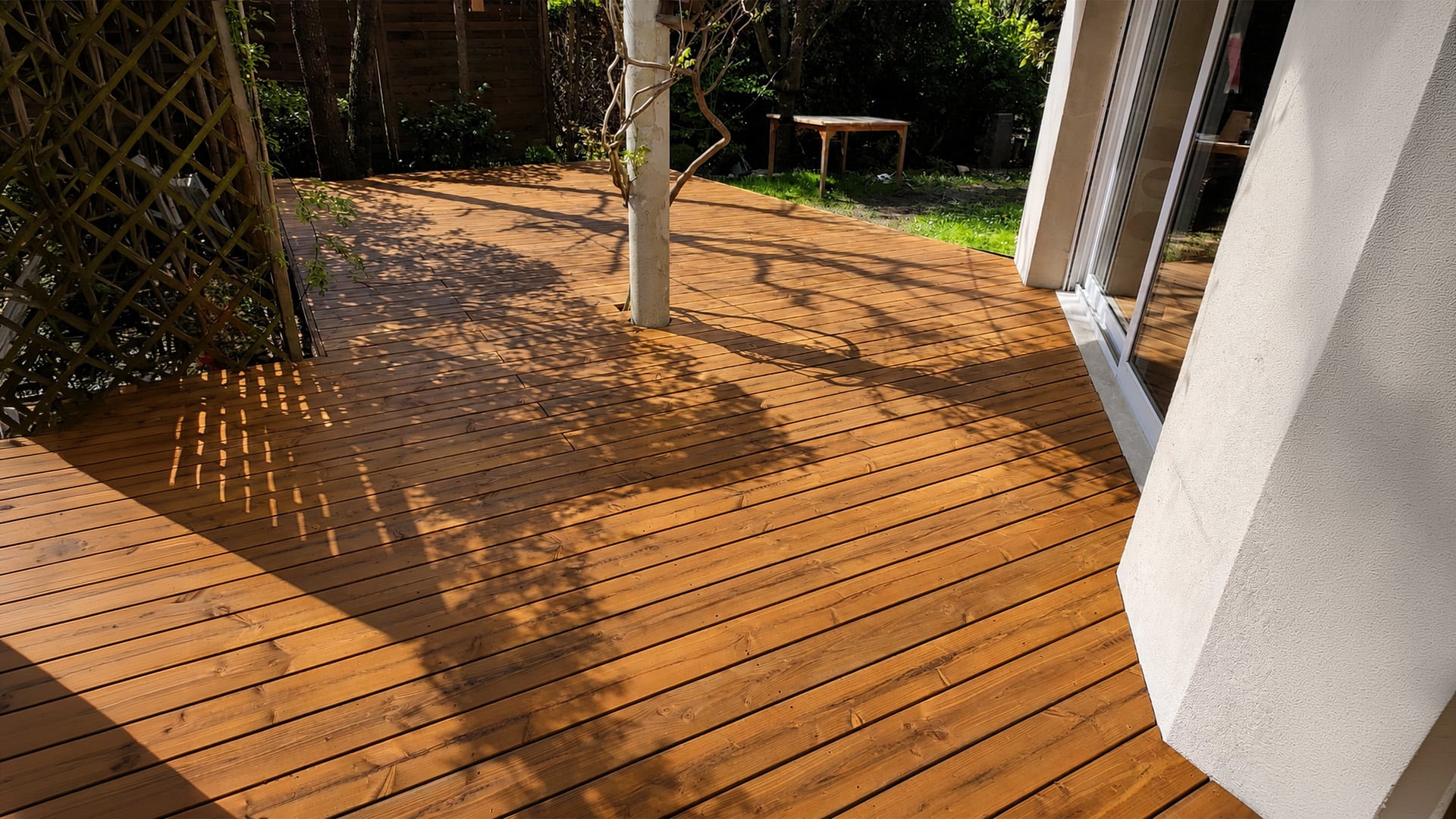 Terrasse en pin extérieur rénovée avec une finition bois chaleureuse après nettoyage, dégrisage et protection du bois.