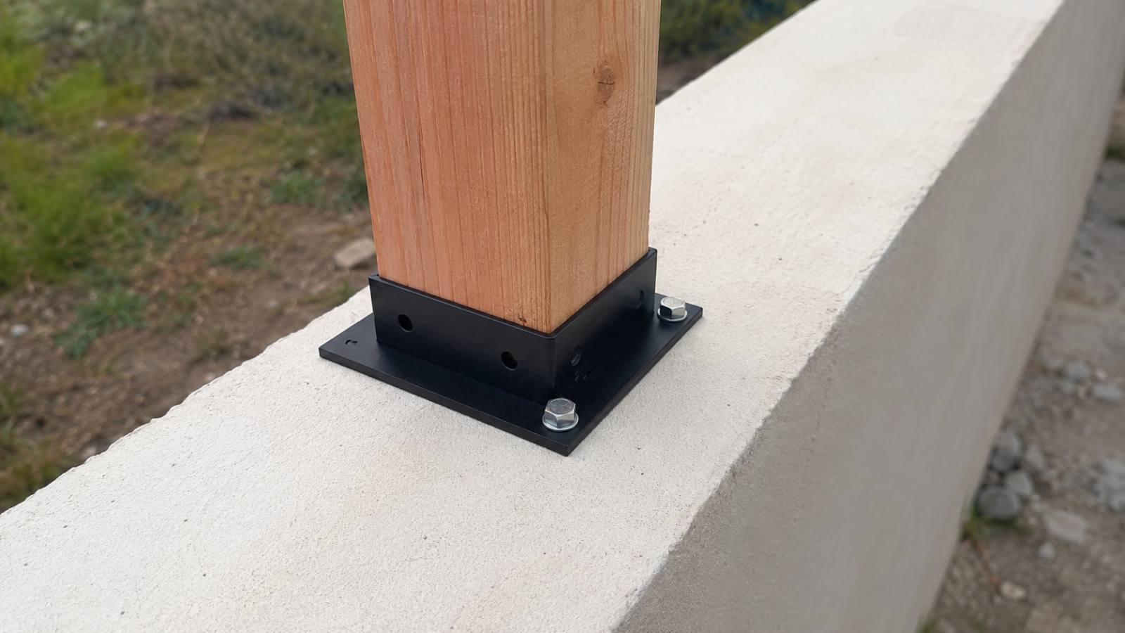 Fixer une clôture bois sur un muret : platine, scellement et erreurs à éviter 1 Platine acier galvanisé boulonnée par goujons d ancrage sur la tête d un muret béton avec poteau bois de clôture vissé dessus
