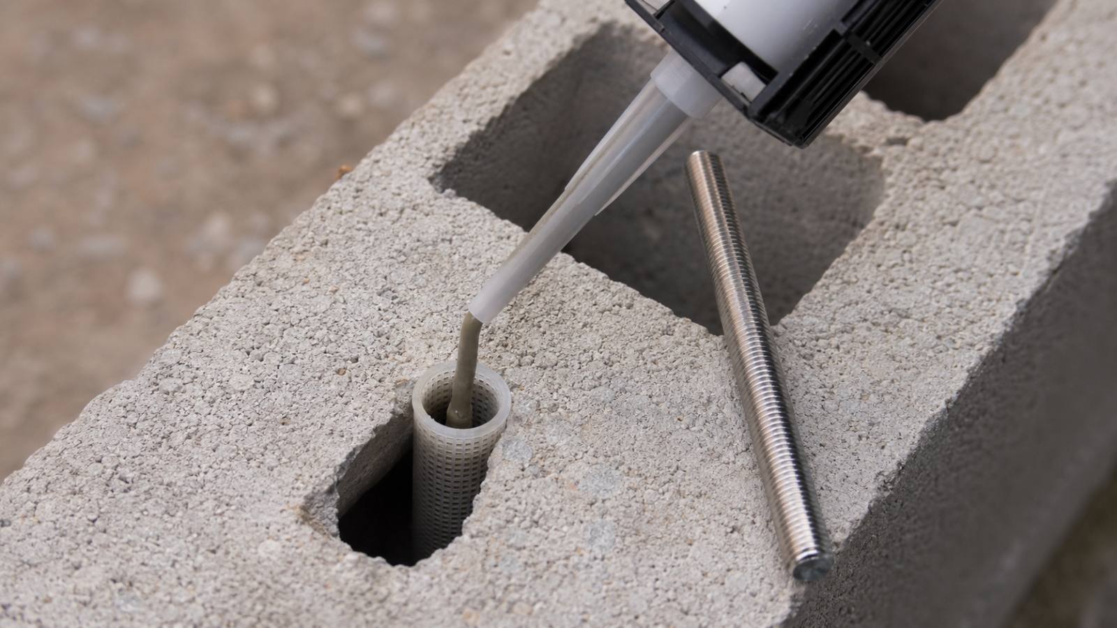 Fixer une clôture bois sur un muret : platine, scellement et erreurs à éviter 2 Tamis manchon grillagé inséré dans l alvéole d un parpaing creux avec injection de résine et tige filetée pour scellement chimique