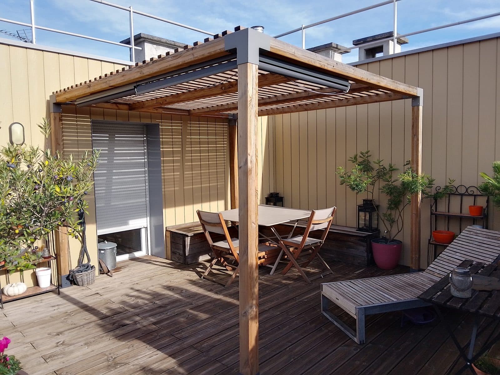 Pergola bois ou alu : le comparatif pour bien choisir 1 pergola bois en lamellé-collé installée sur une terrasse avec table et plantes